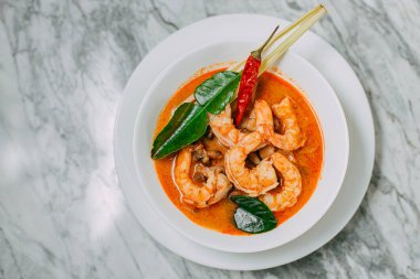 Tom yum karides ve pirinç mermer bir masada beyaz bir tabakta