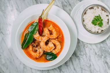 Tom yum karides ve pirinç mermer bir masada beyaz bir tabakta