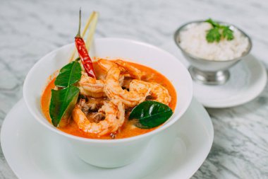 Tom yum karides ve pirinç mermer bir masada beyaz bir tabakta