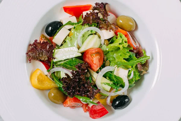 Tomate Vegetariano Ensalada Pimiento Aceitunas Plato Blanco Sobre Una Mesa —  Fotos de Stock