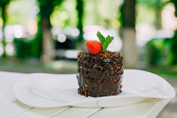 Schokoladenkuchen Mit Nüssen Erdbeeren Und Minze Einem Weißen Teller Auf — Stockfoto