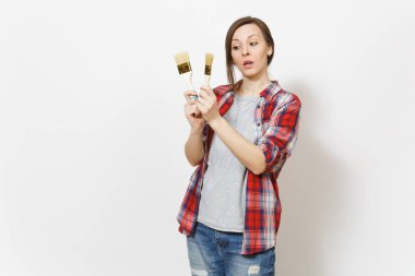 Genç güzel kadını rahat kıyafetler Boya fırçaları beyaz arka plan üzerinde izole tutarak ilgili. Aletleri, yenileme daire oda için aksesuarlar. Onarım ev concept. Reklam alanı