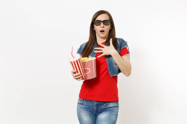 Elini göğsüne tutarak Kova patlamış mısır ve kola veya kola, plastik bardak tutan genç korkmuş kadın 3d gözlük film filmi izlerken portresi beyaz arka plan üzerinde izole. Sinema duygular