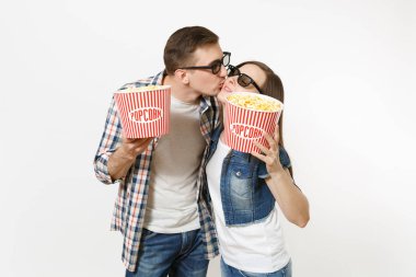 Genç mutlu çift, kadın ve 3d gözlük ve rahat kıyafetler film film izlerken patlamış mısır, kova tutarak tarihte sarılma ve öpüşme izole üzerinde beyaz arka plan adam. Sinema kavramı duygular