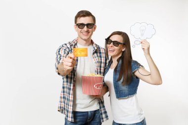 Young couple, woman and man in 3d glasses watching movie film on date holding bucket of popcorn, say cloud with lightbulb, idea and credit card isolated on white background. Emotions in cinema clipart