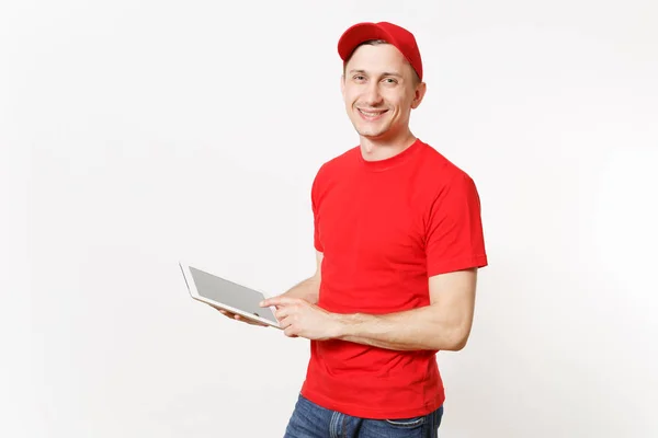 stock image Delivery man in red uniform isolated on white background. Male in cap, t-shirt, jeans working as courier or dealer, holding tablet pc computer with blank empty screen. Copy space for advertisement