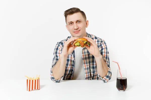 ハンバーガー フライド ポテト 白い背景で隔離のガラスでコーラのテーブルに座っているシャツでハンサムな若い男 適切な栄養やアメリカの古典的なファーストフード 広告コピー スペース付きのエリア — ストック写真