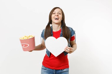 Film film izlerken, beyaz arka plan üzerinde izole boşaltmak ile kova patlamış mısır ve beyaz kalp tutan rahat kıyafetler genç gülmek güzel kadın portresi. Sinema kavramı duygular