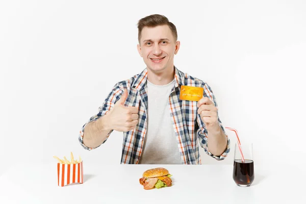 クレジット カード ハンバーガー フライド ポテト 白い背景で隔離のガラスでコーラのテーブルに座っているハンサムな男 適切な栄養やアメリカの古典的なファーストフード 広告コピー スペース付きのエリア — ストック写真