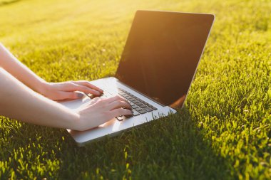 Eller klavye üstüne kapatın. Yeşil çim Güneş'ın bahçesinde açık havada park alanı kopyalamak için dizüstü pc bilgisayar boş siyah Boþ ekran ile üzerinde çalışan kadın. Mobil ofis. Serbest iş kavramı