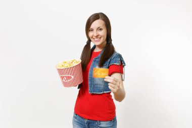 Film film izlerken, kova patlamış mısır ve kredi kartı beyaz arka plan üzerinde izole tutarak rahat kıyafetler içinde genç gülümseyen çekici esmer kadın portresi. Sinema kavramı duygular