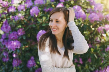 Güzel seksi esmer saçları çekici gülümseme hafif rahat kıyafetler giymiş olan kadın portresi. Çiçekli çalı şehir Park'ta açık havada bahar doğa yakınındaki erkek gülümseyen. Yaşam tarzı kavramı