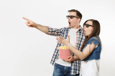 Genç çift, kadın ve erkekte tarihte film film izlerken, kova patlamış mısır holding, beyaz arka plan üzerinde izole boşaltmak üzerinde işaret parmakları işaret 3d gözlük şok. Sinema kavramı duygular