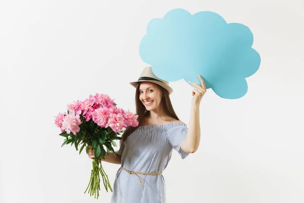 Young woman in blue dress, hat holding blank empty say cloud, speech bubble with place text, bouquet of pink peonies flowers isolated on white background. Holiday concept. Advertising area copy space