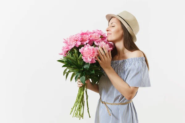 Young tender woman in blue dress, hat holding bouquet of beautiful pink peonies flowers isolated on white background. St. Valentine's Day, International Women's Day holiday concept. Advertising area