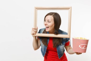 Film film izlerken, kova patlamış mısır ve resim çerçevesinin tutarak, bir kenara boşaltmak izole beyaz arka plan üzerinde seyir genç gülümseyen güzel esmer kadın portresi. Sinema kavramı duygular