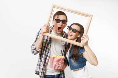 Genç mutlu çift, kadın ve erkek 3d gözlük ve rahat kıyafetler tarihte, film film izlerken patlamış mısır ve resim çerçeve beyaz arka plan üzerinde izole kova tutarak. Sinema kavramı duygular