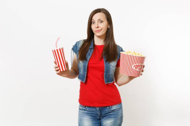 Film film izlerken, kova patlamış mısır ve kola veya kola beyaz arka plan üzerinde izole plastik bardak tutan rahat kıyafetler genç ilgili çekici kadın portresi. Sinema kavramı duygular