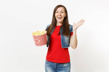 Genç gülen portre rahat kıyafetler film film izlerken, kova patlamış mısır holding ve beyaz arka plan üzerinde izole el yayılan güzel kadın çok memnun. Sinema kavramı duygular