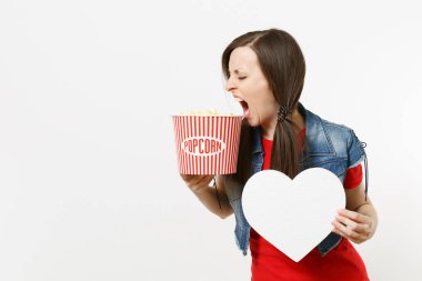 Film film izlerken, beyaz arka plan üzerinde izole boşaltmak ile kova patlamış mısır ve beyaz kalp tutan rahat kıyafetler genç deli çok esmer kadın portresi. Sinema kavramı duygular