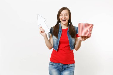 Film film izlerken, kova patlamış mısır holding, boşaltmak izole beyaz arka plan üzerinde beyaz ok yukarıyı rahat kıyafetler içinde genç gülümseyen kadın portresi. Sinema kavramı duygular