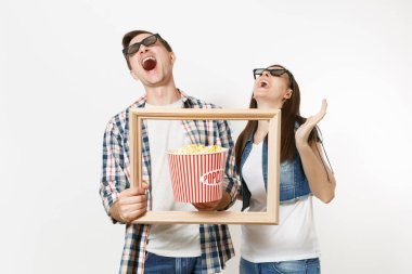 Genç çift, kadın ve erkekte 3d gözlük ve rahat kıyafetler tarihte film film izlerken gülmekten, kova patlamış mısır ve resim çerçevesinin holding beyaz arka plan üzerinde izole. Sinema kavramı duygular