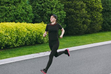 Siyah üniforma giyen genç atletik kız ve eğitim, spor egzersizleri yapıyor, çalıştıran, düz yolda Şehir Park açık havada bahar ya da yaz güneşli günde seyir kap. Fitness, sağlıklı yaşam konsepti