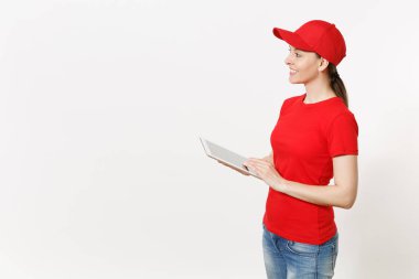 Beyaz arka plan üzerinde izole kırmızı üniformalı teslim kadın. Şu kadın kurye veya satıcısı olarak çalışan, tablet pc bilgisayar boş boş ekran ile tutan kap, t-shirt, kot pantolon. Kopyalama alanı reklam