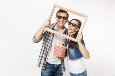 Genç çift, kadın ve erkekte 3d gözlük ve rahat kıyafetler tarihte film film izlerken gülümsüyor, kova patlamış mısır ve resim çerçevesinin holding beyaz arka plan üzerinde izole. Sinema kavramı duygular