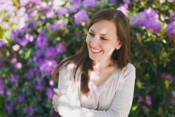 Güzel seksi esmer saçları çekici gülümseme hafif rahat kıyafetler giymiş olan kadın portresi. Çiçekli çalı şehir Park'ta açık havada bahar doğa yakınındaki erkek gülümseyen. Yaşam tarzı kavramı