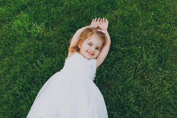 Χαμογελώντας Μωρό Κοριτσάκι Χαριτωμένο Παιδί Ψέμα Φως Φόρεμα Πράσινο Γρασίδι — Φωτογραφία Αρχείου