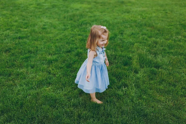 Denim, oldukça küçük şirin çocuk bebek kız ayakta Giydir oynamak ve eğlenmek Park yeşil çim çim üzerinde. Anne, küçük çocuk kızı. Anneler günü, aşk aile, ebeveynlik, çocukluk kavramı