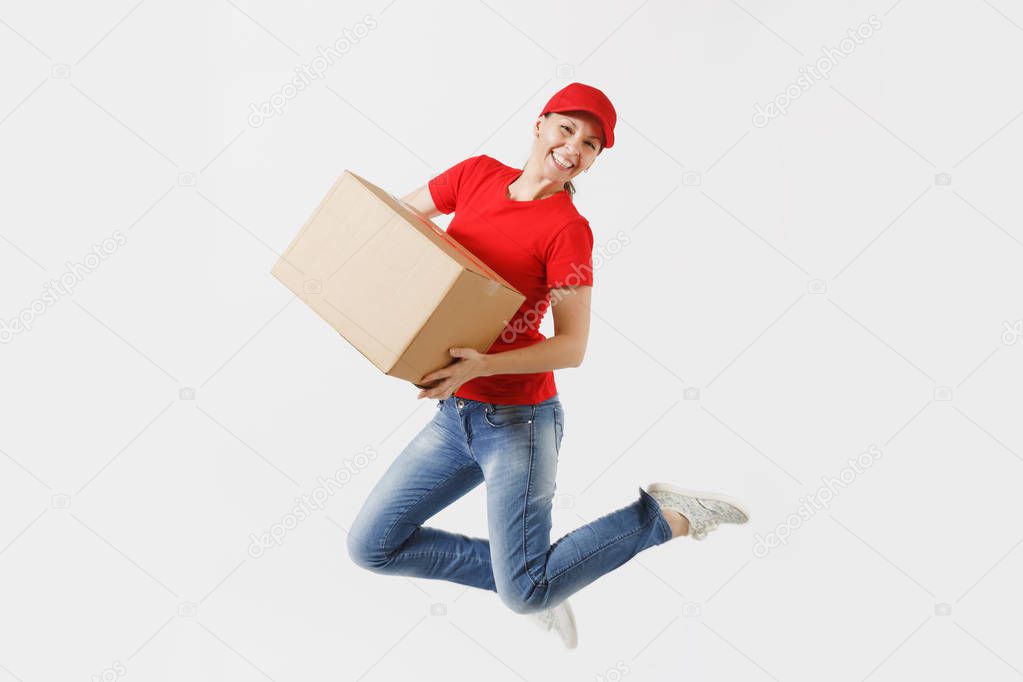 Full length portrait of fun delivery woman in red cap, t-shirt isolated on white background. Female courier or dealer jumping with empty cardboard box. Receiving package. Copy space for advertisement