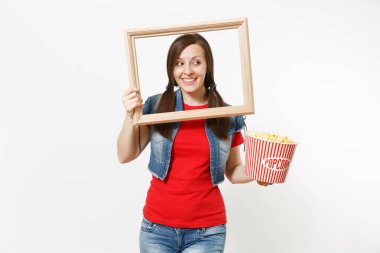 Film film izlerken, kova patlamış mısır ve resim çerçevesinin tutarak, bir kenara boşaltmak izole beyaz arka plan üzerinde seyir genç gülümseyen güzel esmer kadın portresi. Sinema kavramı duygular