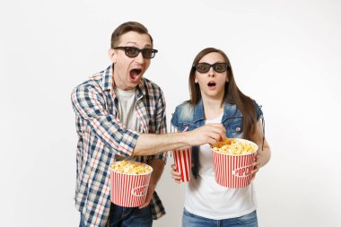 Genç şok çift, kadın ve erkekte 3d gözlük tutan Kova patlamış mısır, plastik bardak kola veya kola, tarihte film film izlerken patlamış mısır çalmak beyaz arka plan üzerinde izole. Sinema duygular