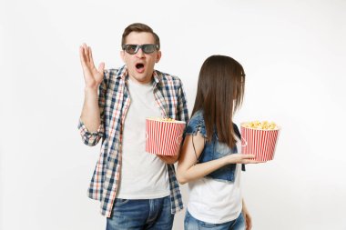 Genç memnun çift, kadını ve kova patlamış mısır, beyaz arka plan üzerinde izole eller yayılan tutan adam 3d gözlük ve rahat kıyafetler tarihte, film film izlerken. Sinema duygular