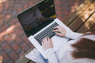 Kırpılan başarılı eller klavye üzerinde kapatın. Modern dizüstü pc bilgisayar açık havada sokakta boş boş ekran ile çalışan bankta oturan kadın. Mobile Office serbest iş kavramı