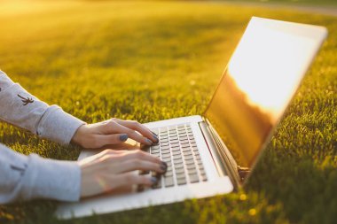 Eller klavye üstüne kapatın. Yeşil çim Güneş'ın bahçesinde açık havada park alanı kopyalamak için dizüstü pc bilgisayar boş siyah Boþ ekran ile üzerinde çalışan kadın. Mobil ofis. Serbest iş kavramı