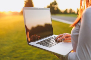 Eller klavye üstüne kapatın. Yeşil çim Güneş'ın bahçesinde açık havada park alanı kopyalamak için dizüstü pc bilgisayar boş siyah Boþ ekran ile üzerinde çalışan kadın. Mobil ofis. Serbest iş kavramı