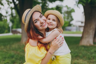 Mutlu kadın sarı elbise oyun parkı yeşil çim çim üzerinde eğlenceli ve sarılmak, kucaklamak küçük şirin çocuk bebek kız var. Anne, küçük çocuk kızı. Anneler günü, aşk aile, ebeveynlik, çocukluk