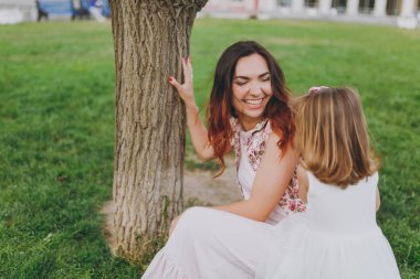 Işık neşeli kadın oyun elbise ve küçük şirin çocuk bebek kız parkta yeşil çim çimenlikte eğlenin. Anne, küçük çocuk kızı. Anneler günü, aşk aile, ebeveynlik, çocukluk kavramı