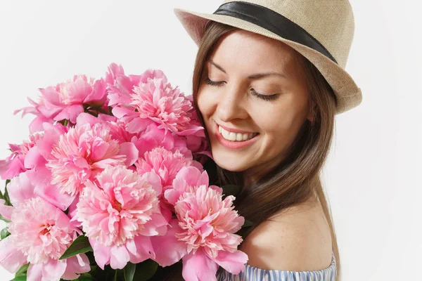 Close up young tender woman in blue dress, hat holding bouquet of pink peonies flowers isolated on white background. St. Valentine\'s Day, International Women\'s Day holiday concept. Advertising area