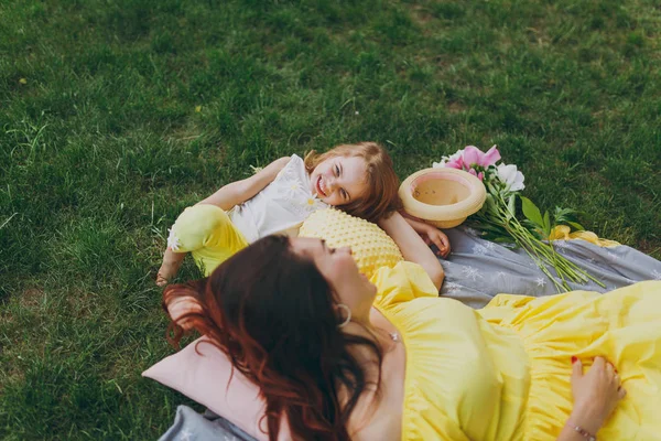 노란색 거짓말에 공원에서 잔디밭에 나머지 귀여운 소녀와 어머니 아이입니다 어머니의 — 스톡 사진