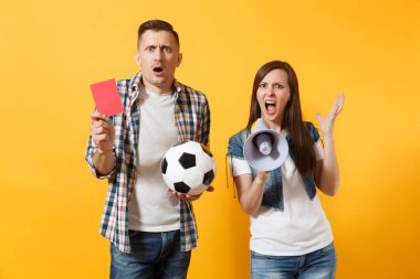 Kızgın eğlenceli expessive çılgın çift, çığlık, kadın erkek futbol taraftarları destek ekibi ile futbol topu, megafon, izole sarı zemin üzerine kırmızı kart neşelendirmek. Spor aile eğlence yaşam tarzı kavramı