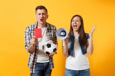 Kızgın eğlenceli expessive çılgın çift, çığlık, kadın erkek futbol taraftarları destek ekibi ile futbol topu, megafon, izole sarı zemin üzerine kırmızı kart neşelendirmek. Spor aile eğlence yaşam tarzı kavramı