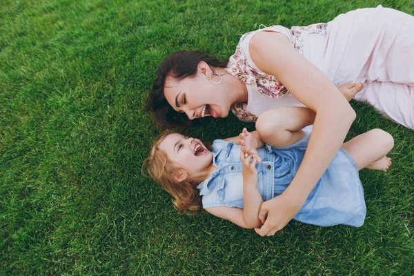 光のドレスの女は ちょっとしたかわいい子の赤ちゃん女の子嘘を笑っている緑の草の芝生のくすぐりをプレイし 楽しい 子供の幼い娘 母の日 愛の家族 子供の頃の概念 — ストック写真