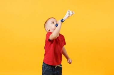 Küçük şirin çocuk bebek çocuk 3-4 yaşında, boru, elinde tutan kırmızı t-shirt futbol fan üfleme üzerinde sarı arka plan izole. Çocuklar spor aile eğlence yaşam tarzı kavramı. Kopyalama alanı reklam