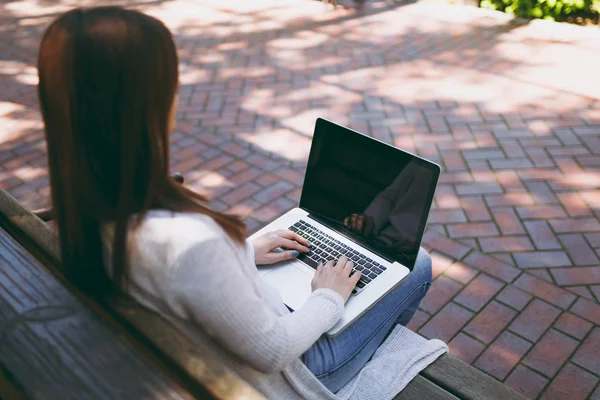 Kırpılan başarılı eller klavye üzerinde kapatın. Modern dizüstü pc bilgisayar açık havada sokakta boş boş ekran ile çalışan bankta oturan kadın. Mobile Office serbest iş kavramı