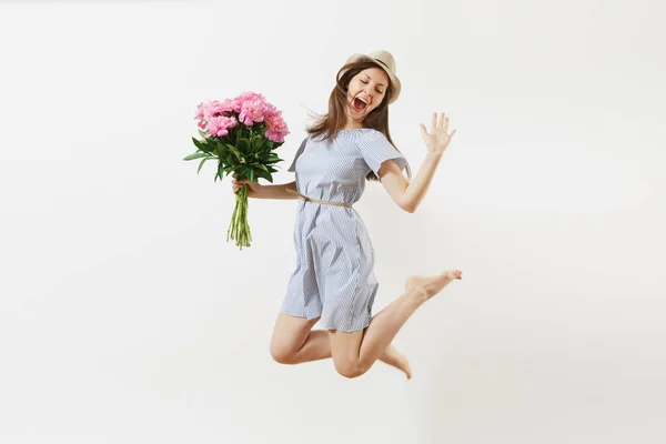 满长的欢乐快乐的年轻女子穿着蓝色的连衣裙 帽子捧着粉红牡丹花的花束 在白色的背景下跳跃开来 情人节 国际妇女节节日概念 — 图库照片