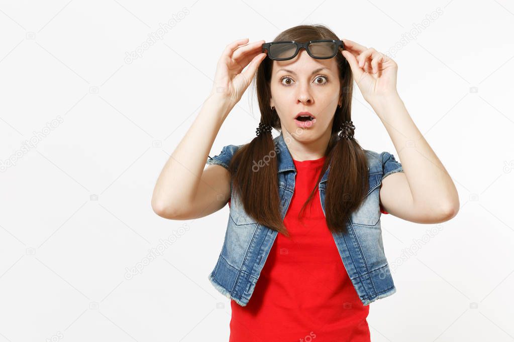 Portrait of young shocked attractive brunette woman with opened mouth in casual clothes watching movie, film, taking off 3d glasses isolated in studio on white background. Emotions in cinema concept.